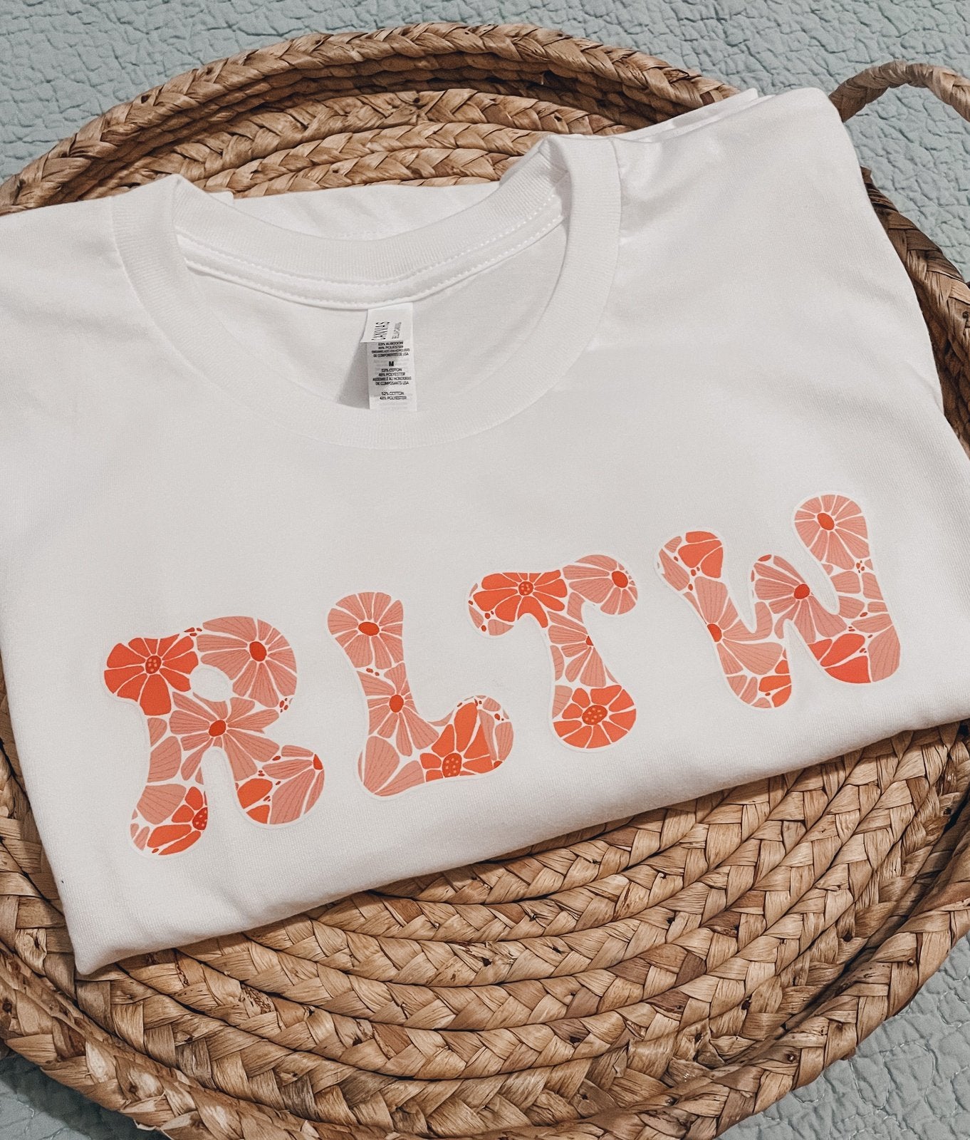 Pink floral RLTW design on a white tee